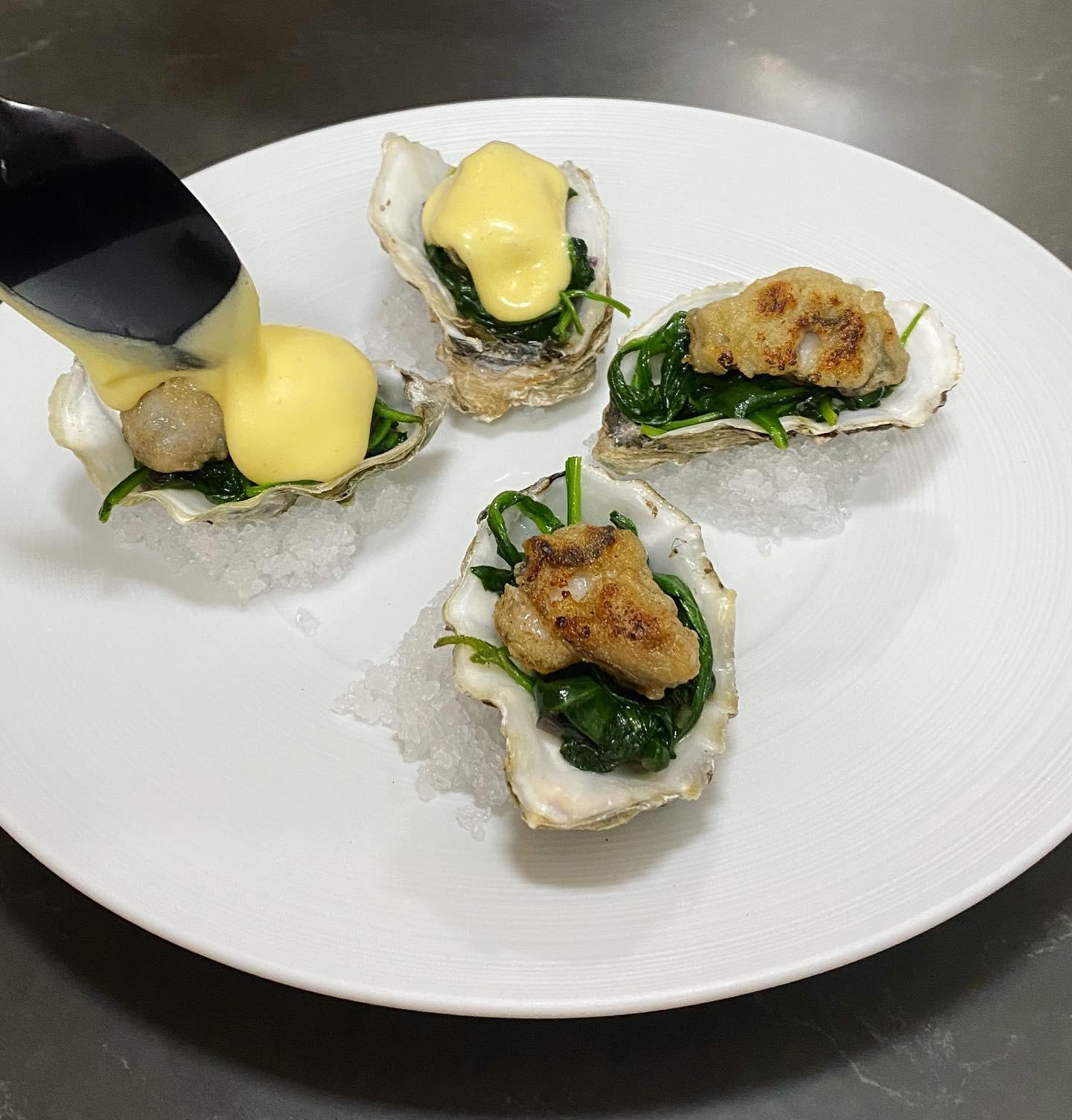 de gebakken oesters met spinazie en hollandaise als extra gerechtje voordat het gerecht begint
